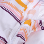Invisible zipper closure on striped duvet cover in white, yellow, pink and plum tones.