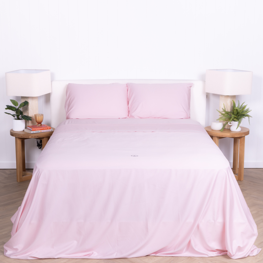 The Lad Collective blush pink bamboo cotton blend bedding set styled on a queen bed, featuring matching pillowcases and flat sheet for a soft, breathable, and modern bedroom look.