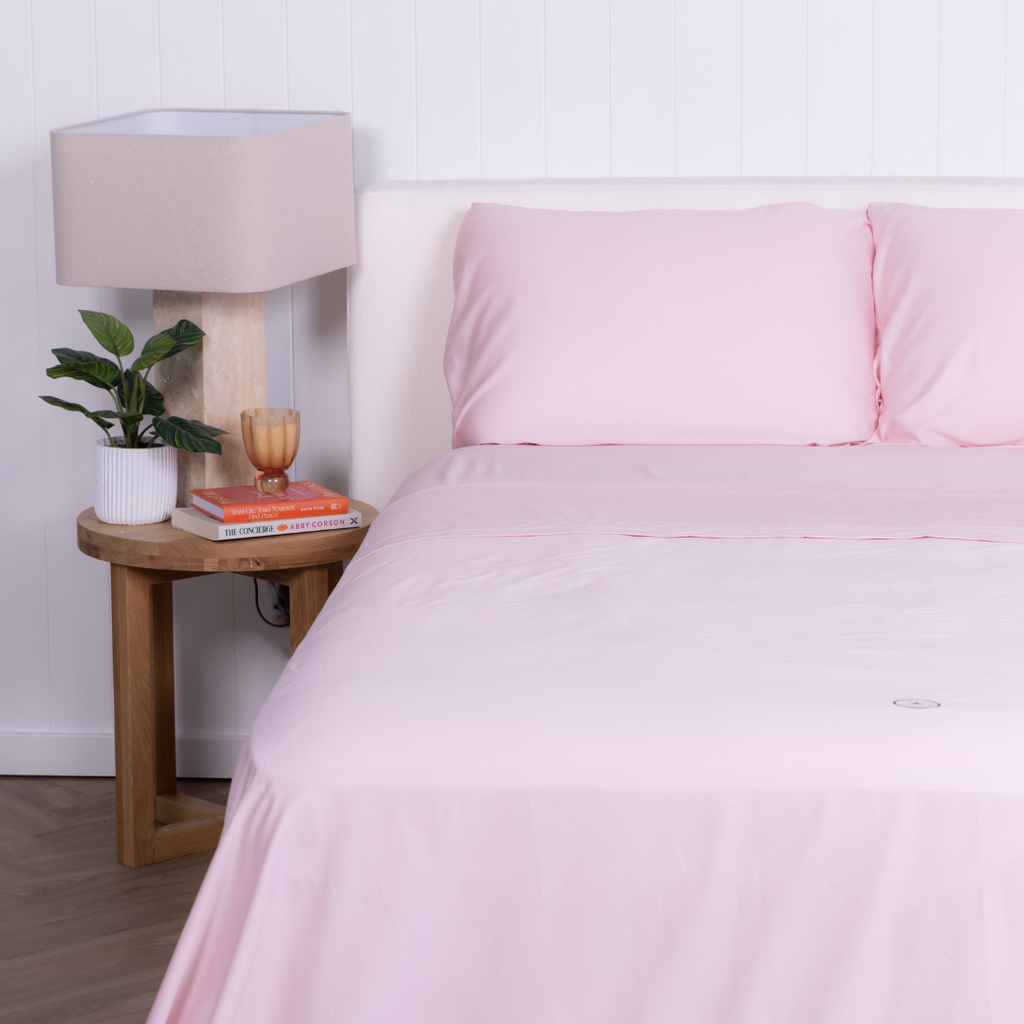The Lad Collective blush pink bamboo cotton blend bedding set styled on a queen bed, featuring matching pillowcases and flat sheet for a soft, breathable, and modern bedroom look.