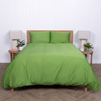 Full shot of bed dressed in Colorado green duvet cover with natural decor elements. 