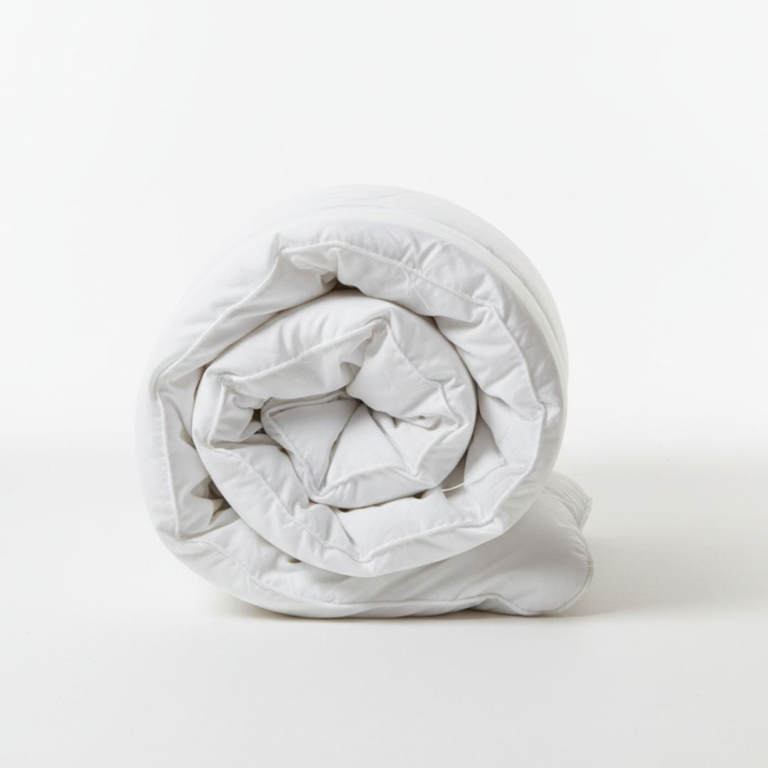 Rolled-up white comforter on a white background