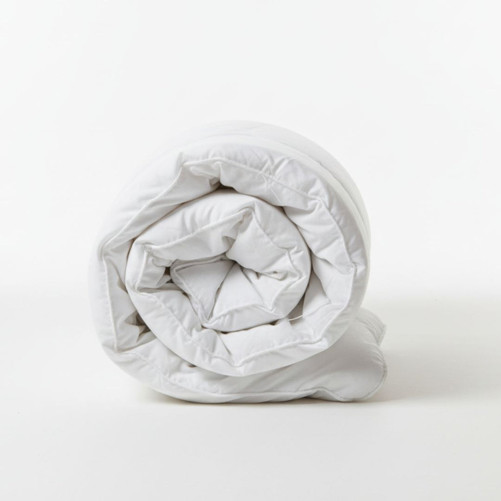 Rolled-up white comforter on a white background