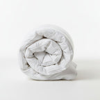 Rolled-up white comforter on a white background
