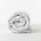 Rolled-up white comforter on a white background