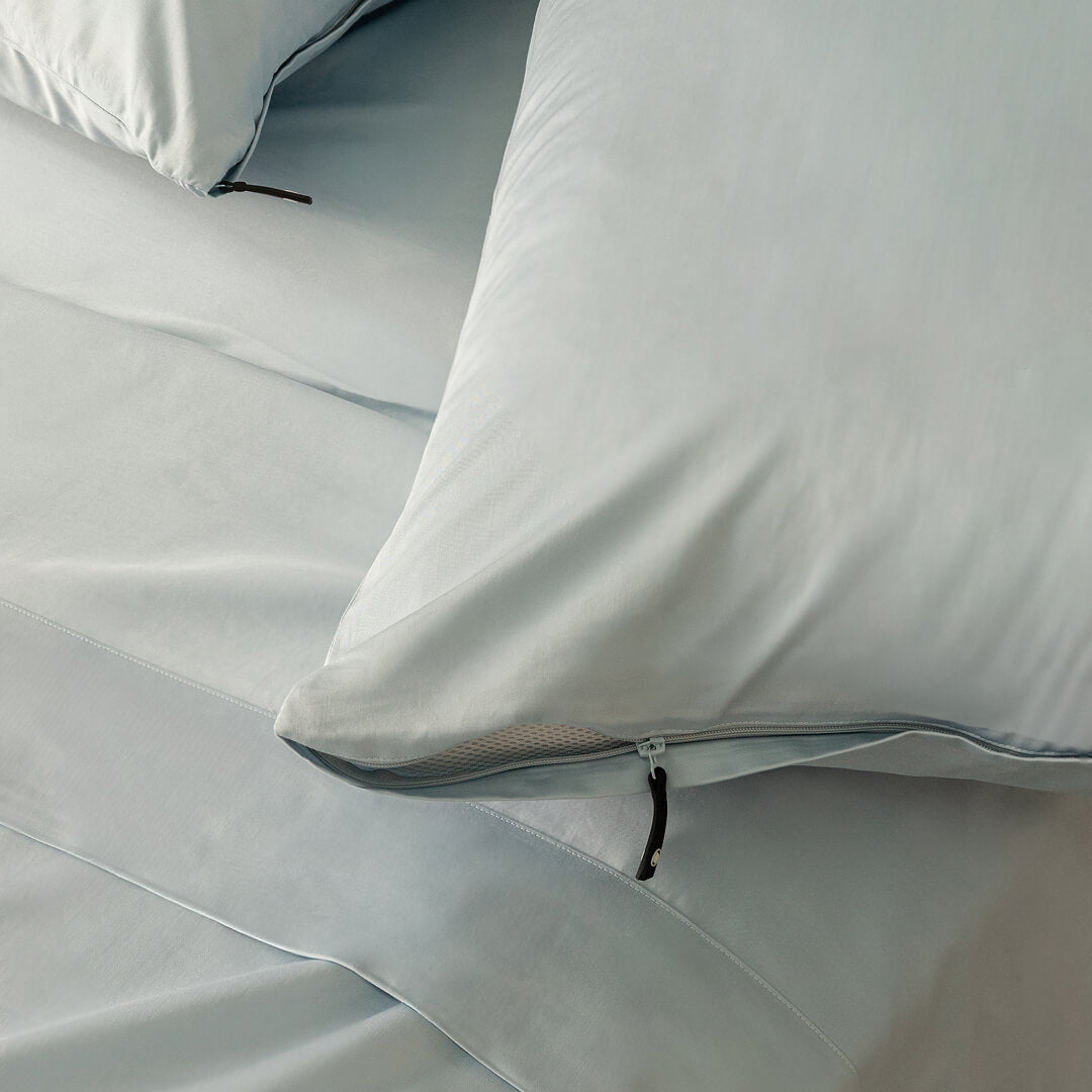 Close-up of light blue pillowcases with zippers.