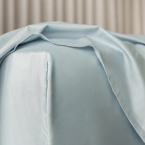 Light blue fitted sheet corner on a neutral background.