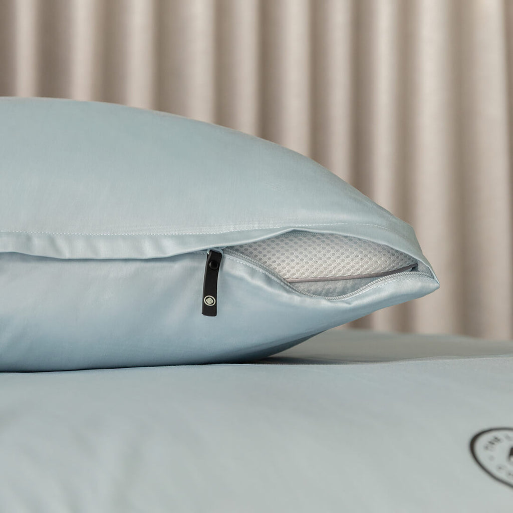 Light blue pillow with zipper on a neutral background.