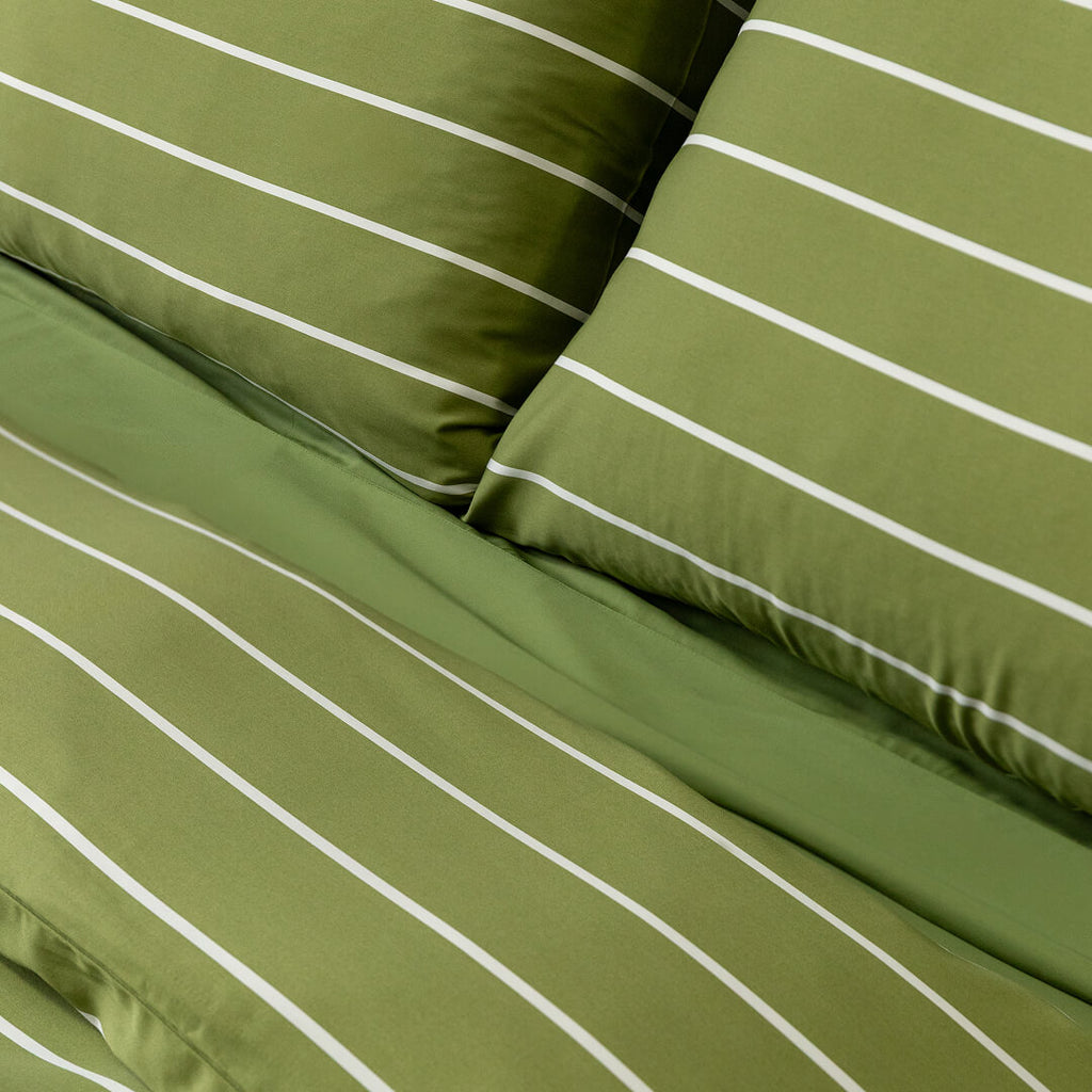 Green striped bedding set with white stripes on a plain background