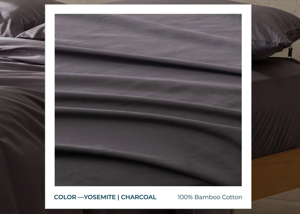 Dark gray bedding set on a bed with text describing the fabric and color.