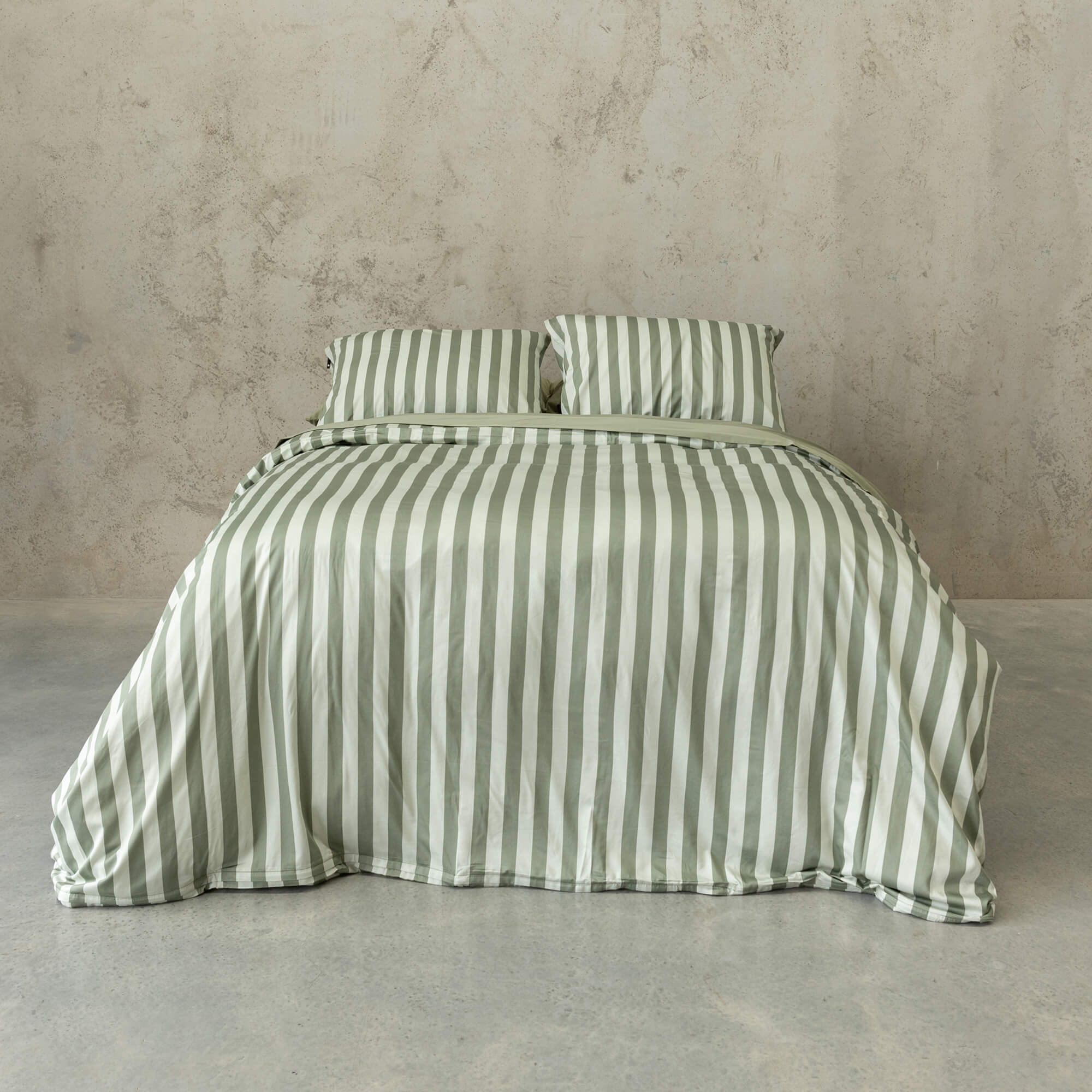 Sage green stripe duvet cover set on a bed, with a neutral background.