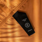Burnt orange fitted sheet labelled corner loop strap that reads 'Bottom Left' and 'Double'. 