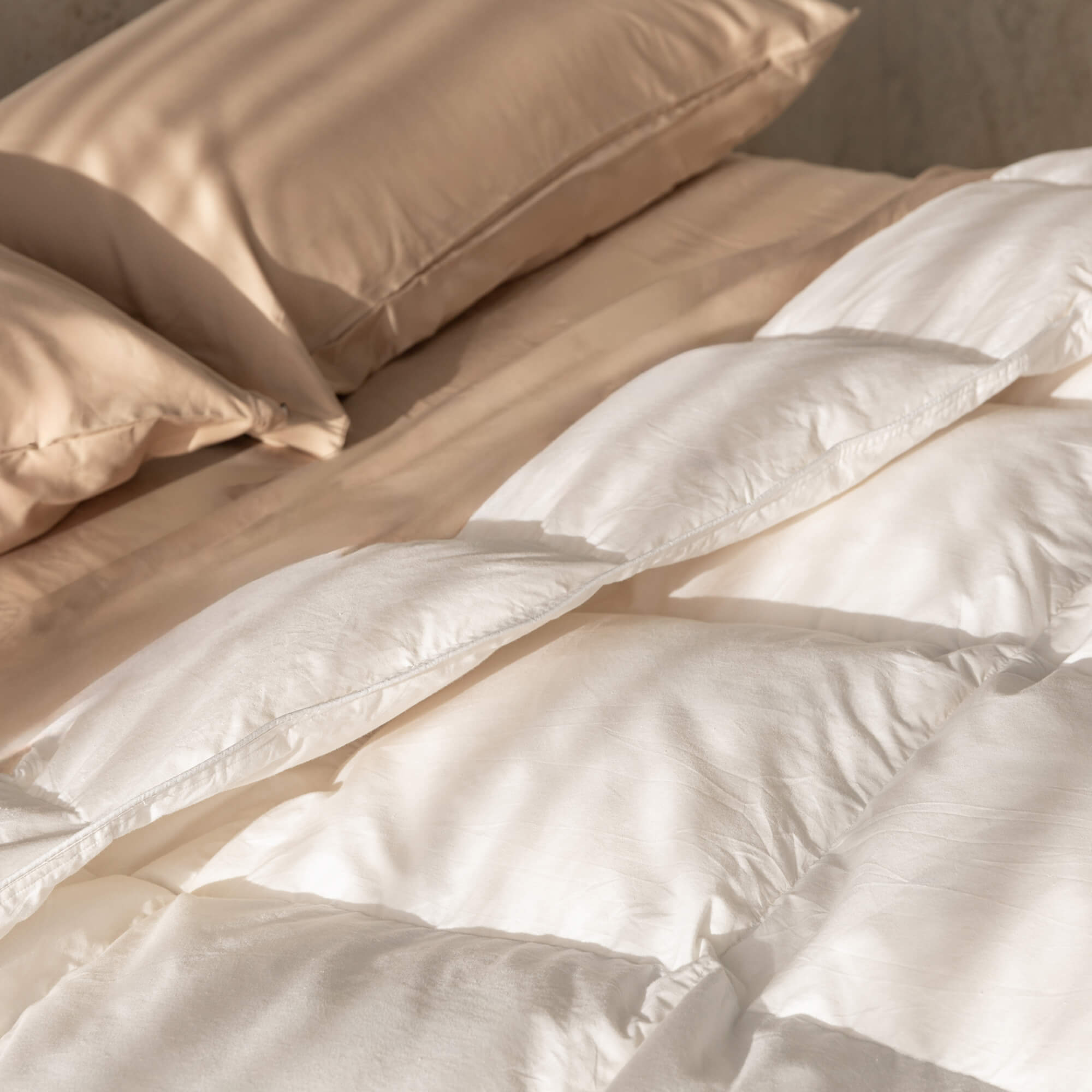 Close-up of beige bedding with a soft texture.
