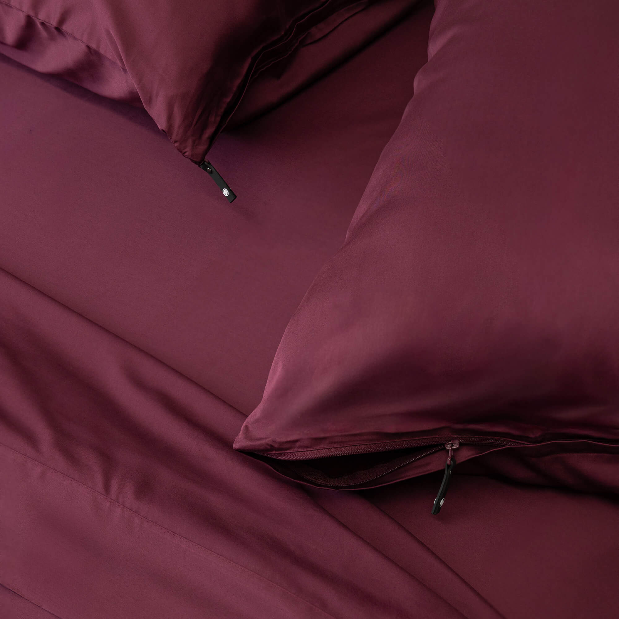Maroon bedding set with pillows on a bed