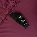 Close-up of a maroon fabric with a black label featuring text and a logo.