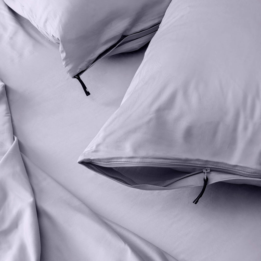 Close up of pillows and pillowcases with zip detail in gray bedding