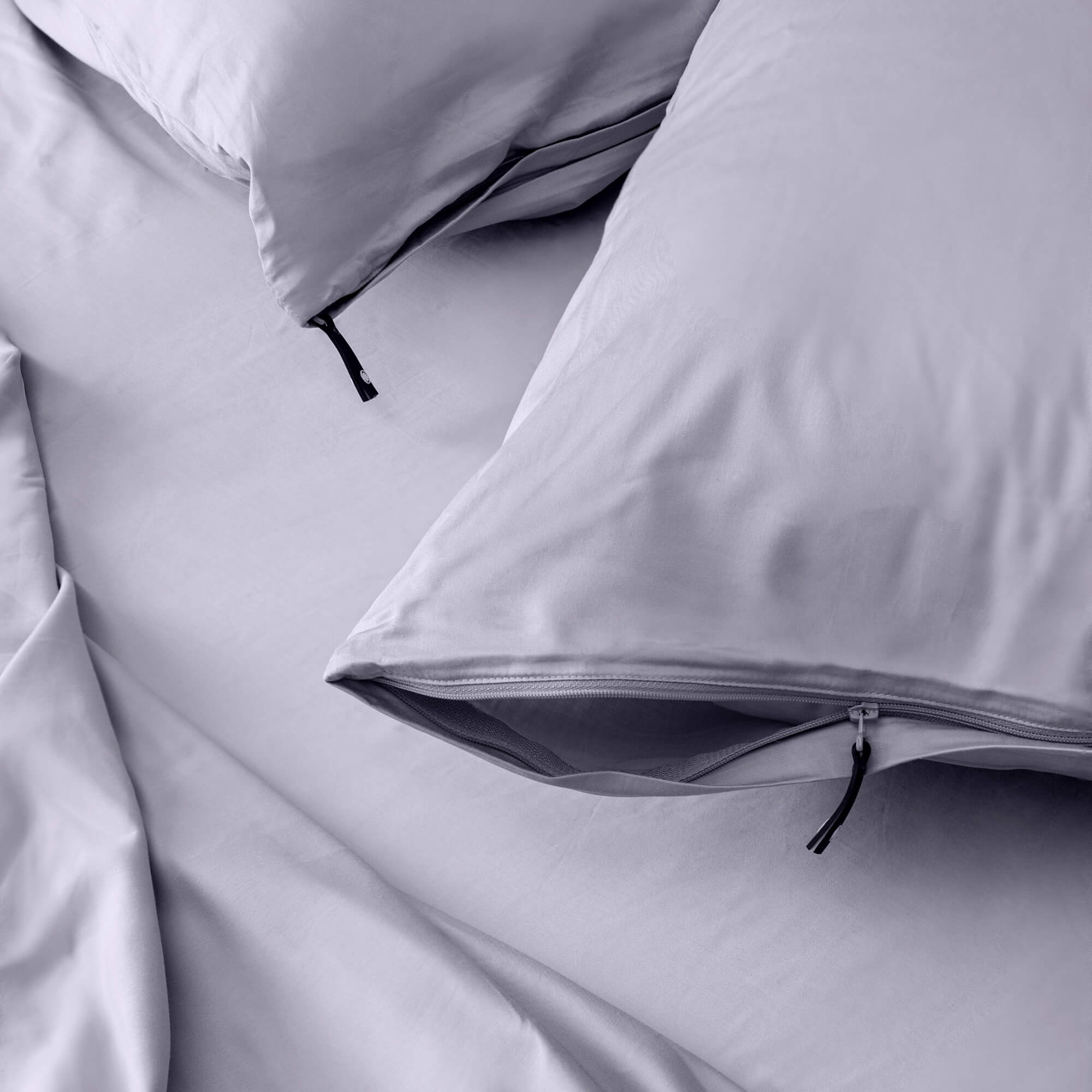 Close up of pillows and pillowcases with zip detail in gray bedding