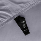 Close up of corner strap of fitted sheet in grey coloured bedding