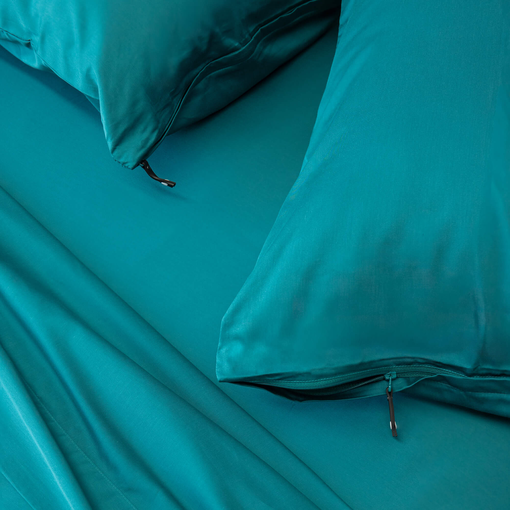 Close up of pillows and pillowcases with zip detail in teal bedding