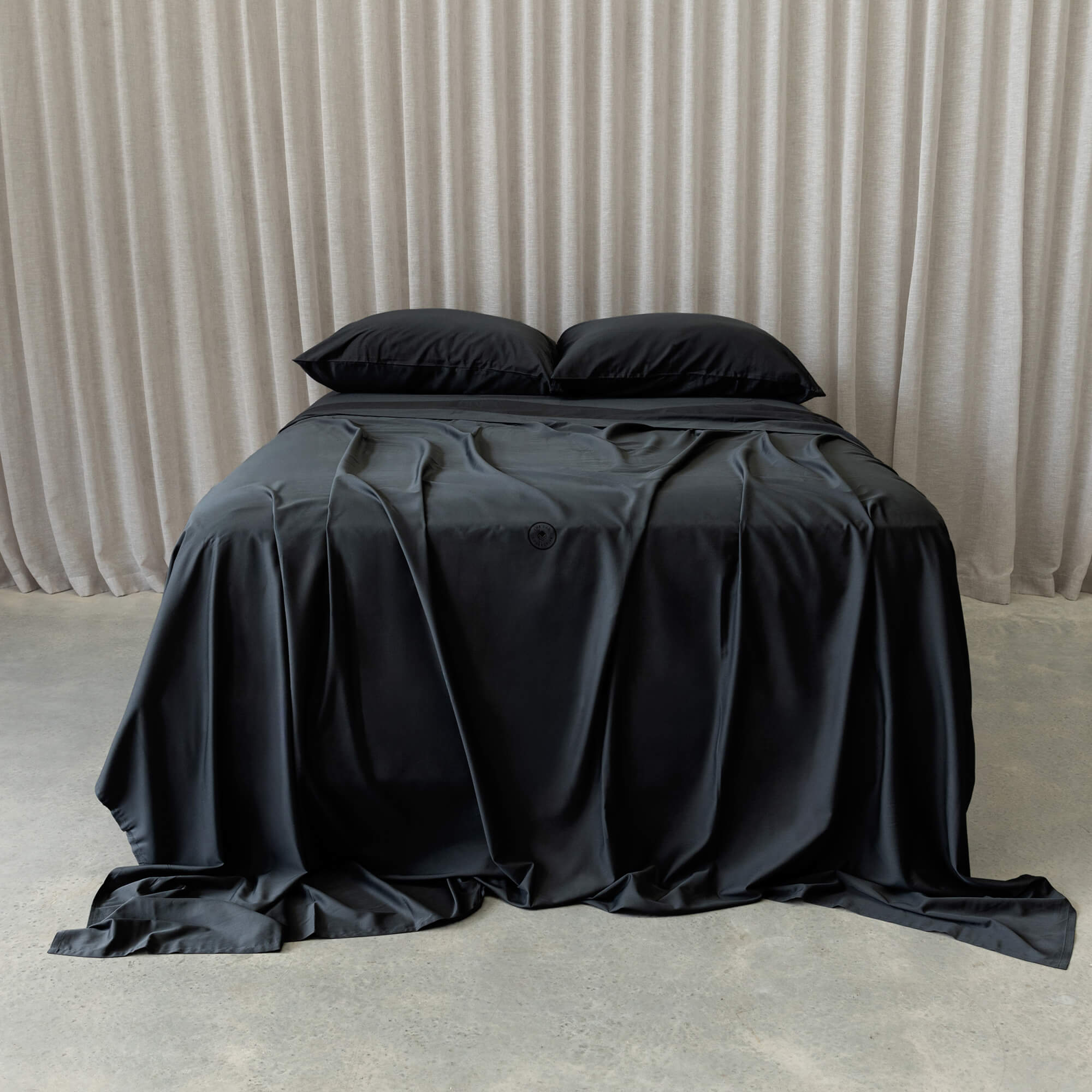 Black bedspread on a bed with a neutral background