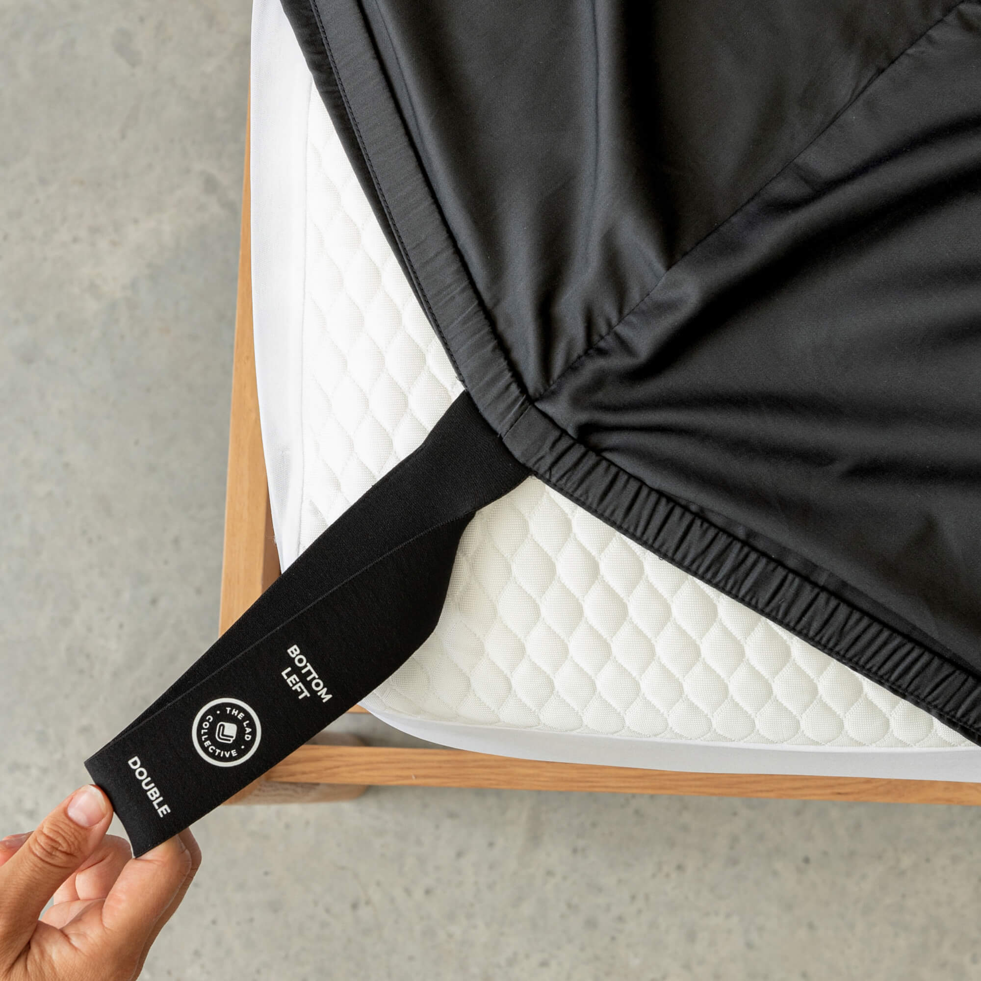 Black mattress support strap with brand logo on a mattress