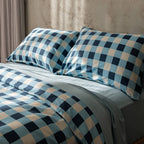 Checkered blue and beige bedding set on a bed with a neutral wall background