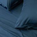 Close up of pillows and pillowcases with zip detail in navy blue bedding

