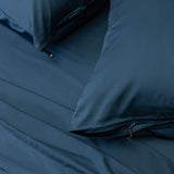 Close up of pillows and pillowcases with zip detail in navy blue bedding
