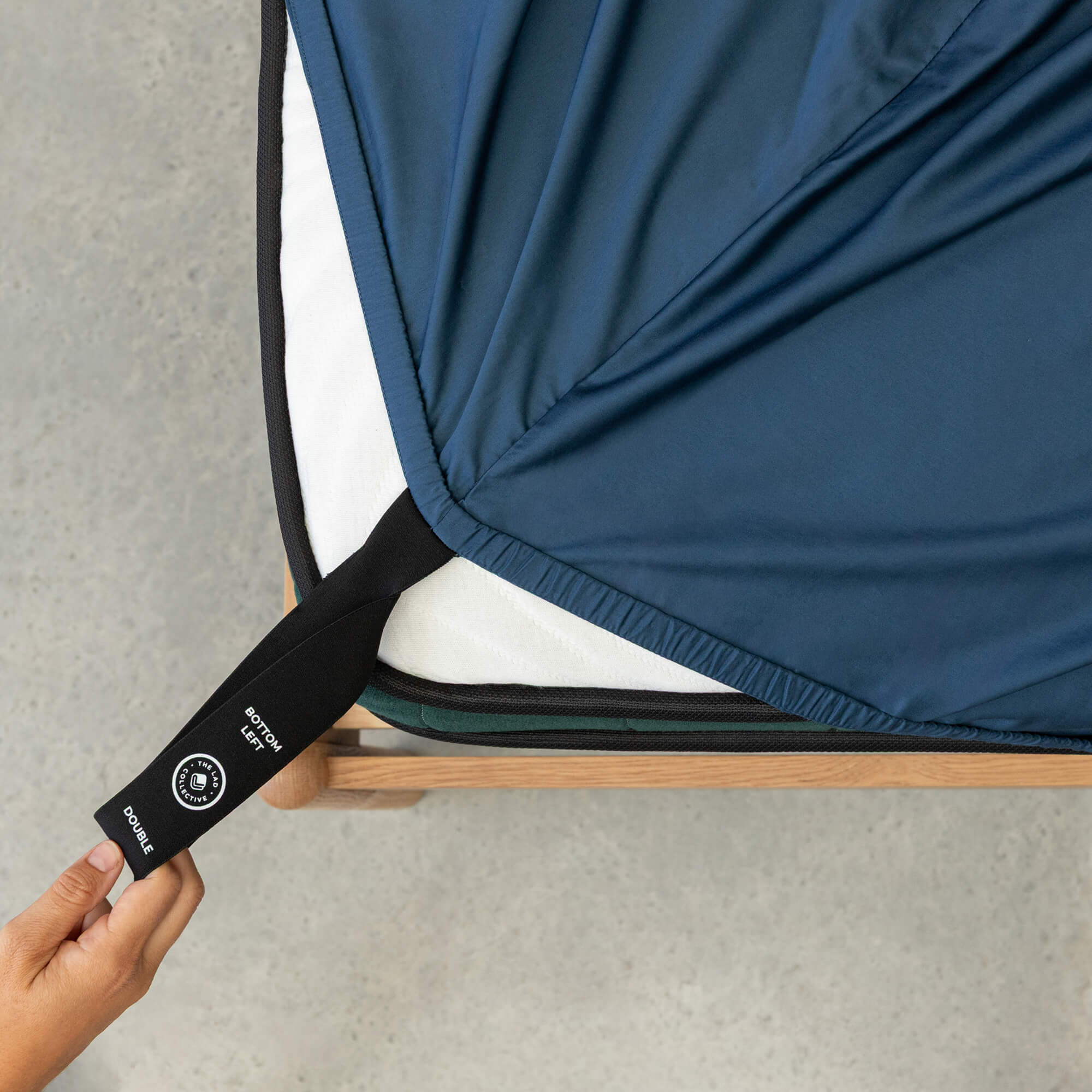 Blue sheets on a bed with black corner straps