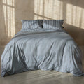 Navy and white pinstripe duvet cover on bed with neutral background.