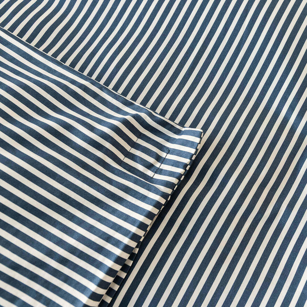Navy and white pinstripe duvet cover magnetic corner close up.
