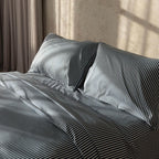 Navy and white pinstripe duvet cover on bed with neutral background.