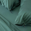 Close up of pillows and pillowcases with zip detail in green bedding
