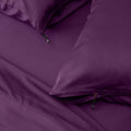 Close-up of purple bedding with a zipper detail on pillowcases.