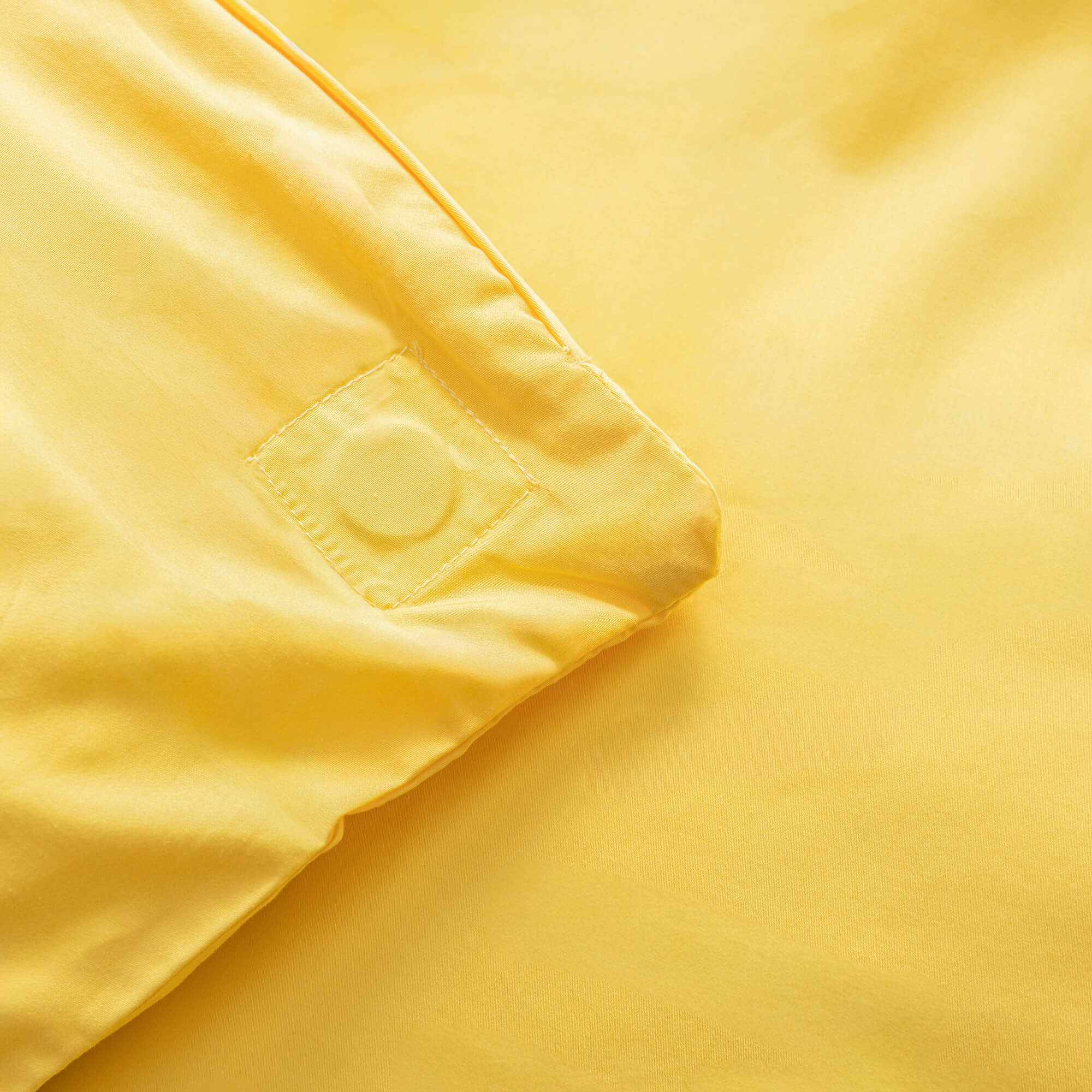 Close up of the magnetic corners in a bright yellow duvet cover. 