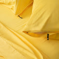 Two bright-yellow invisible zip pillowcases  on the matching bed set.