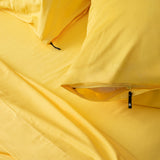 Two bright-yellow invisible zip pillowcases  on the matching bed set.