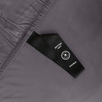 Close up of corner strap of fitted sheet in gray coloured bedding