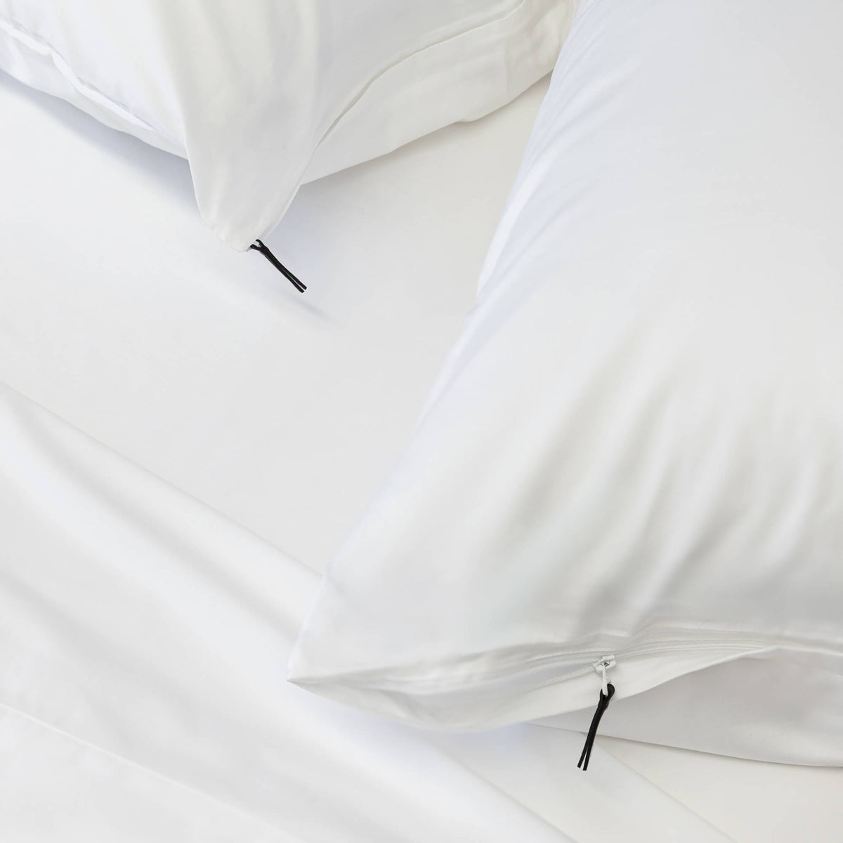 Close-up of a white pillowcase with a zipper on a light gray background