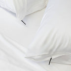 Close-up of a white pillowcase with a zipper on a light gray background