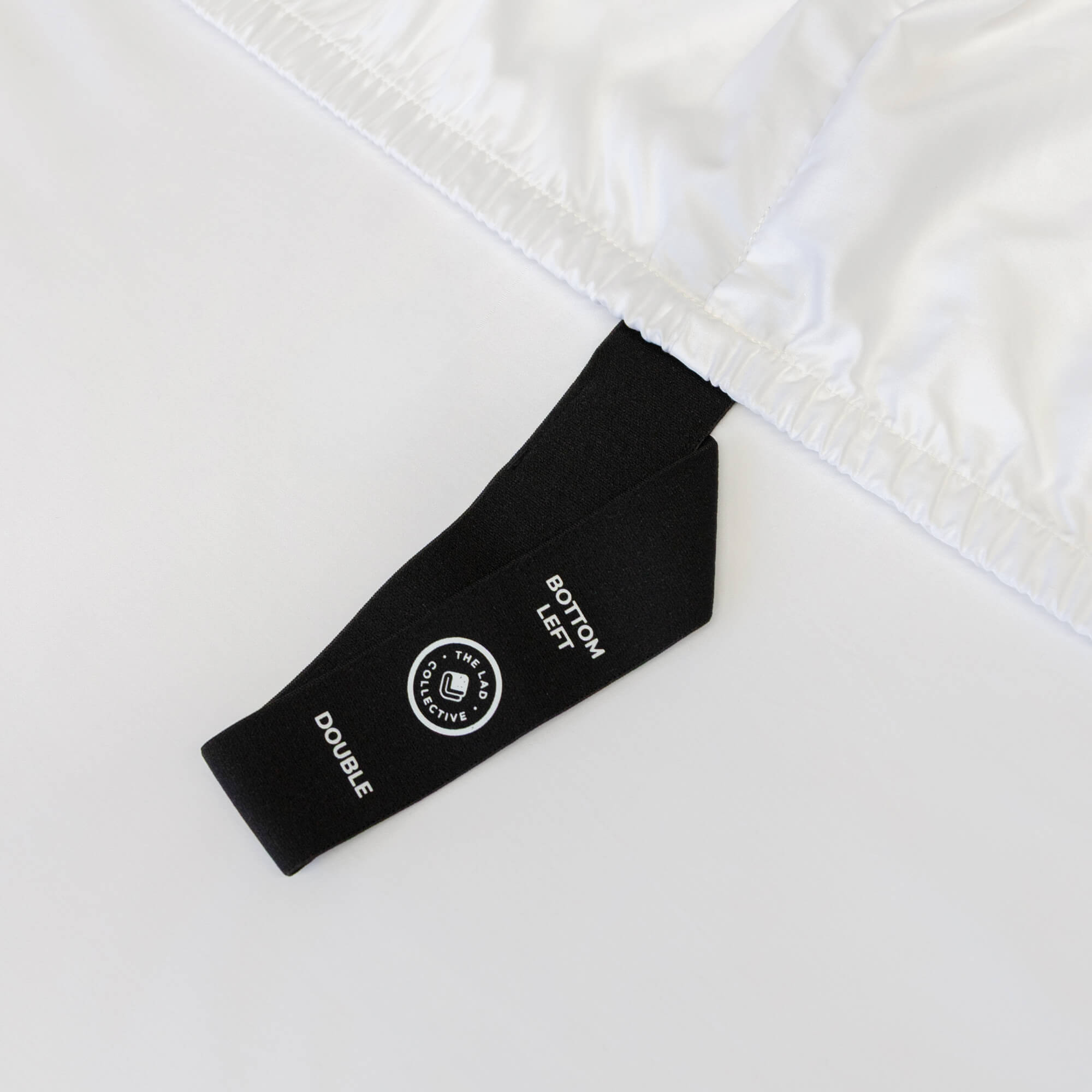 Close-up of a black label on white fabric,  indicating bed sheet size 