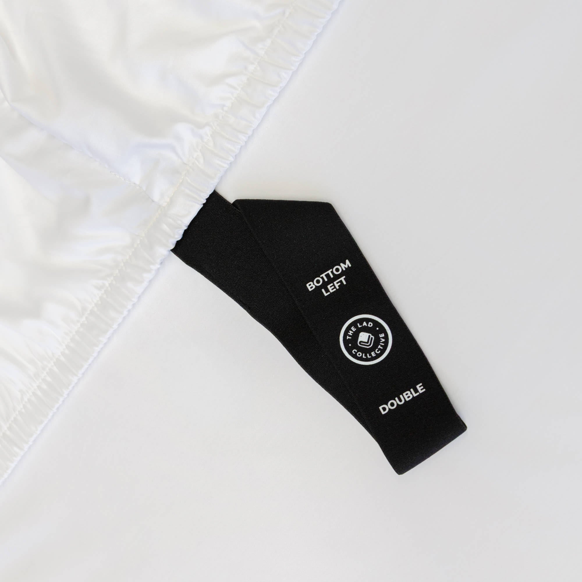 Close-up of a black label on white fabric,  indicating bed sheet size 