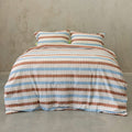 Striped bedspread with brown and blue pattern on a plain background.