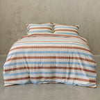 Striped bedspread with brown and blue pattern on a plain background.