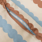 Brown fabric with a blue zipper on a beige background with blue decorative elements