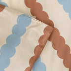 Close-up of fabric with brown and blue cloud patterns on a beige background
