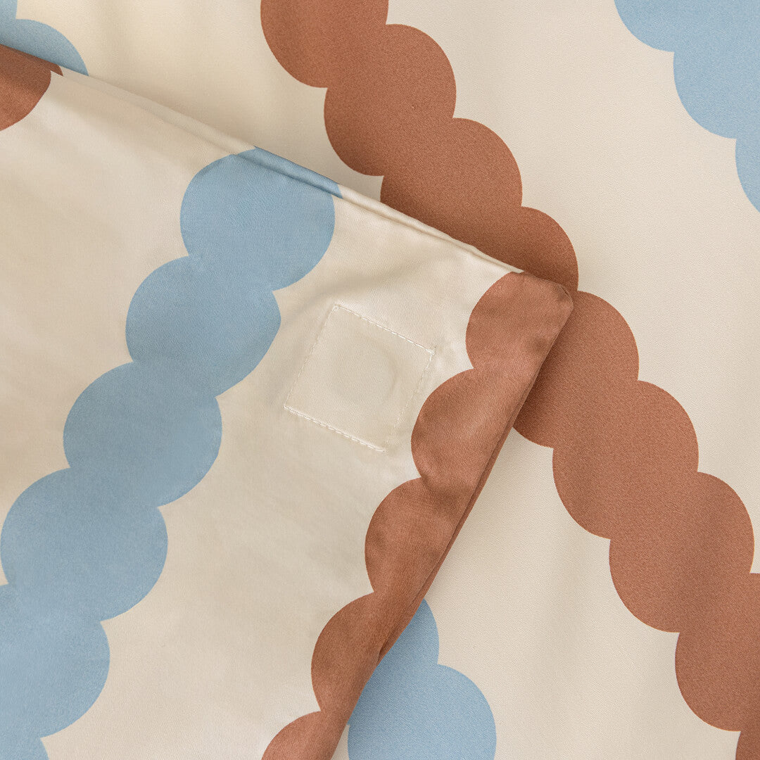 Close-up of fabric with brown and blue cloud patterns on a beige background