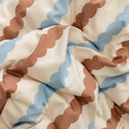 Close-up of fabric with wavy brown and blue pattern on beige background