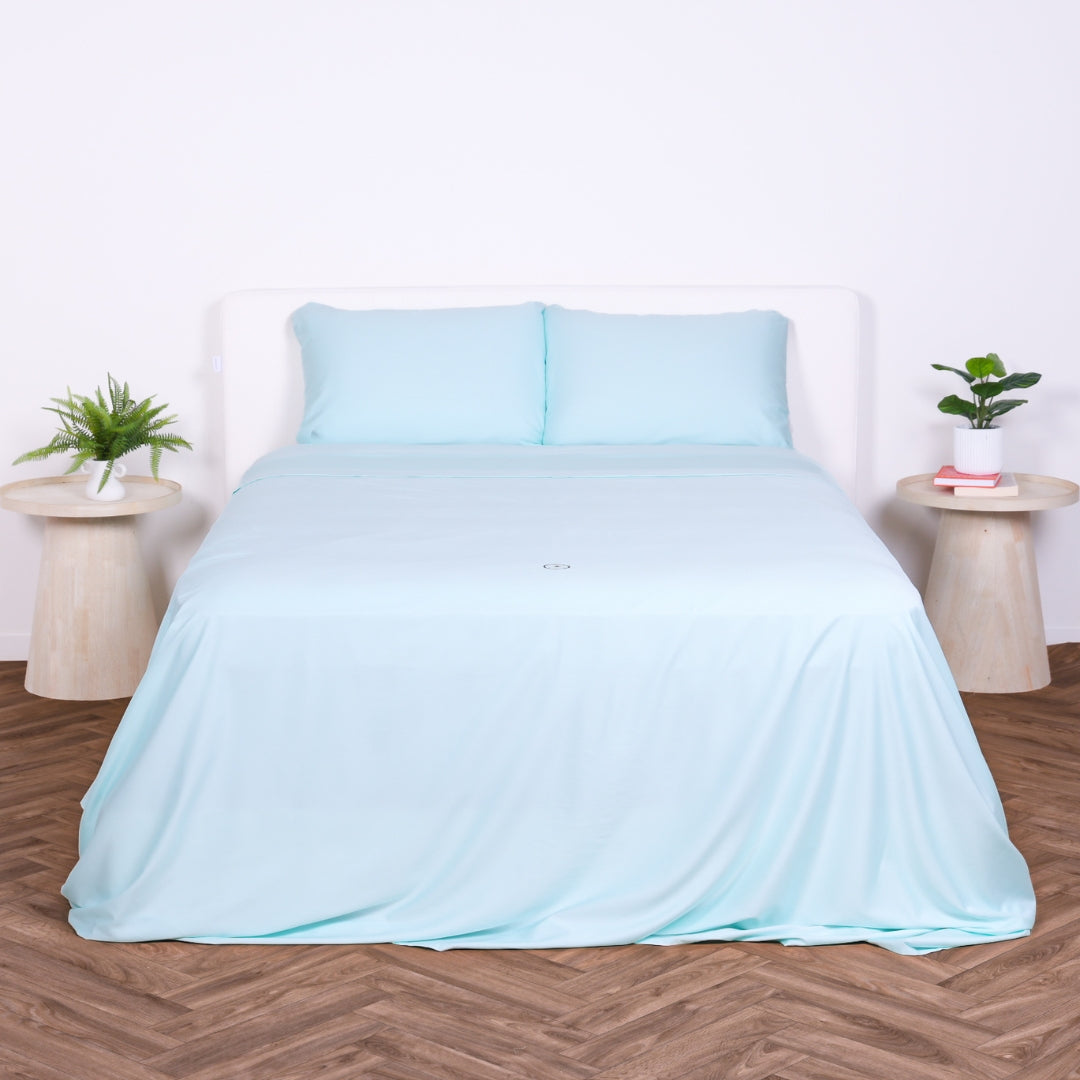 Front view of a bed with Riviera Blue sheet set and two pillows, styled with minimal decor.
