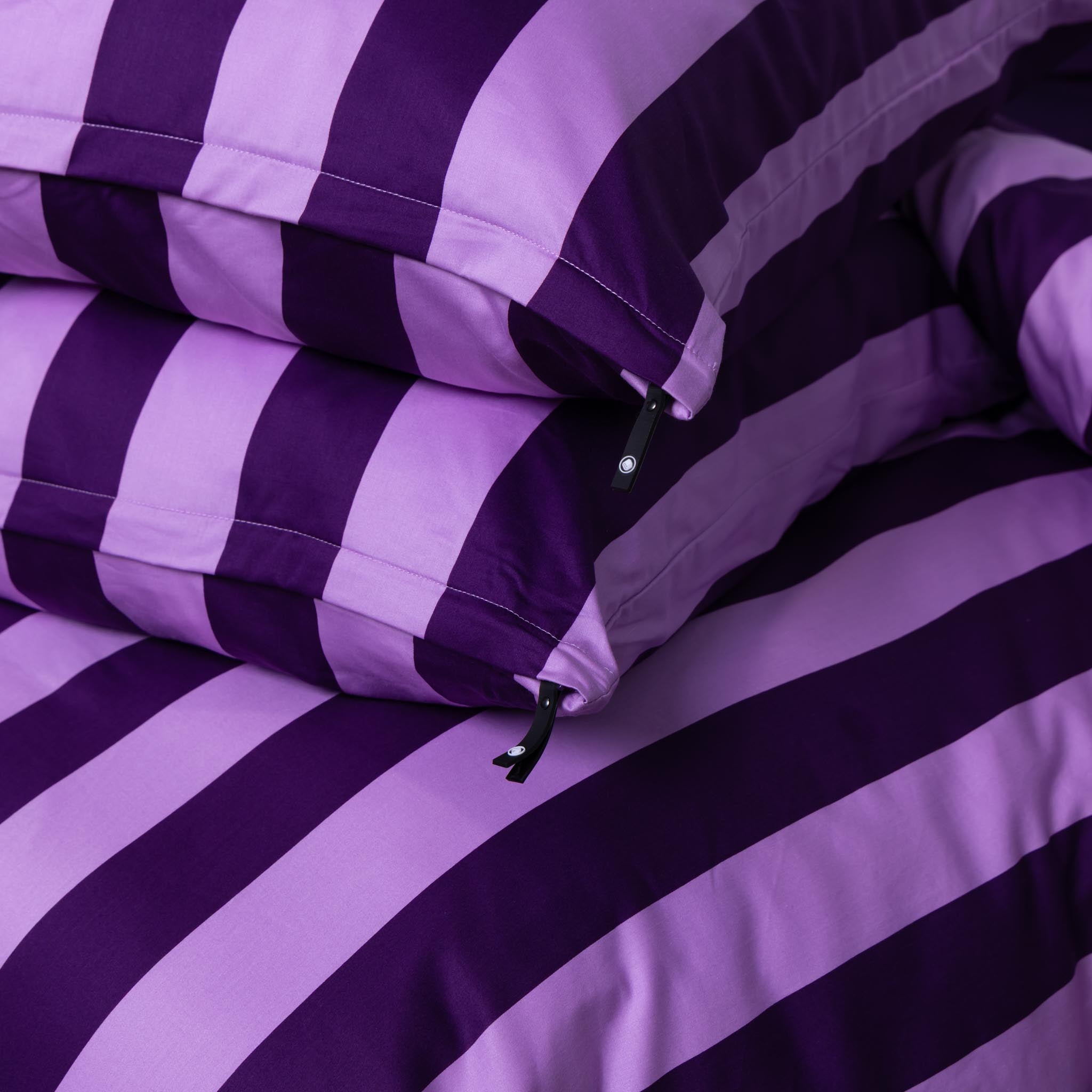 Purple and lilac stripped pillowcases on the matching duvet cover. 
