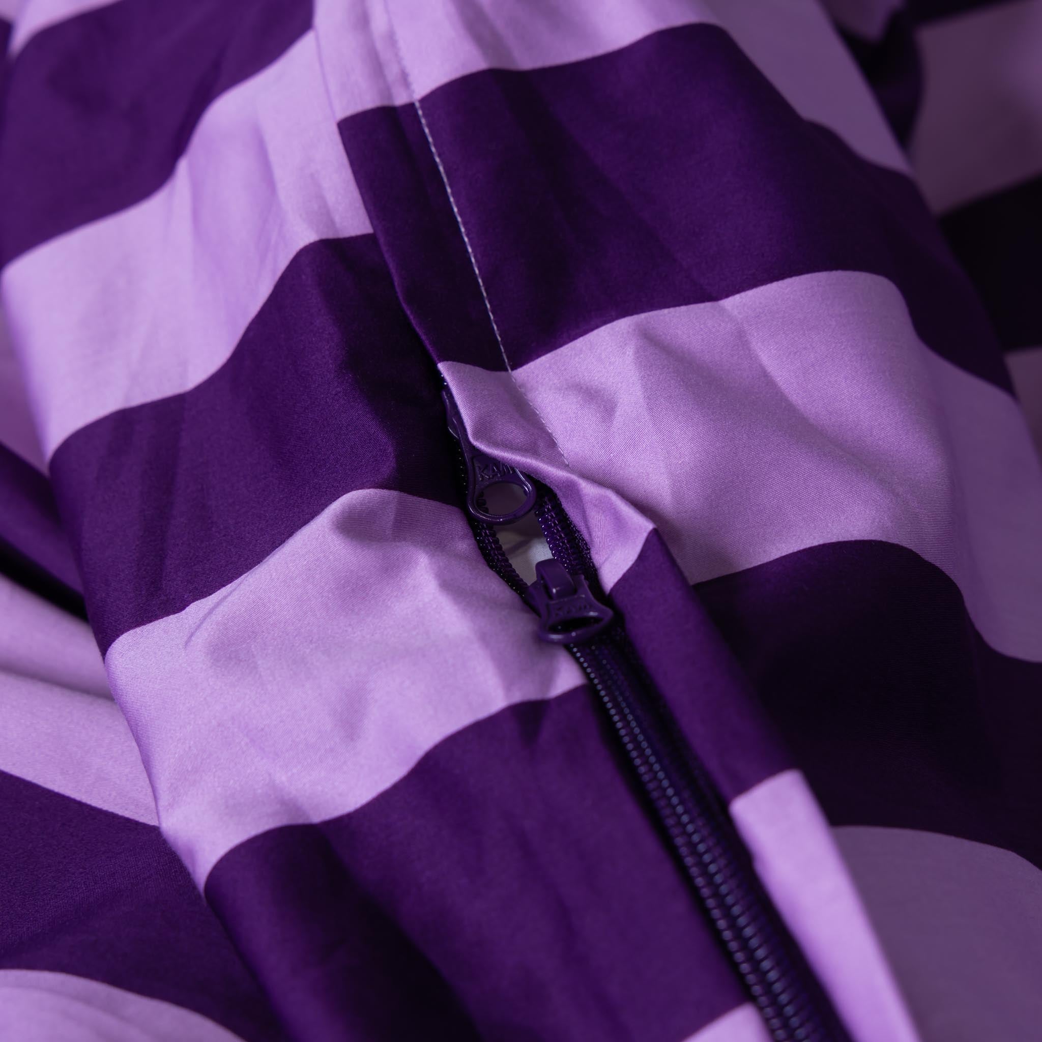 Close-up of a purple and lilac striped duvet cover with a zipper.